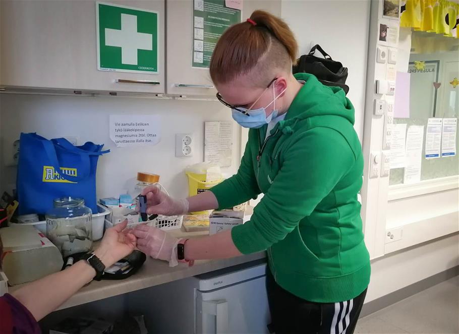Jenna harjoittelee verensokerin mittaamista