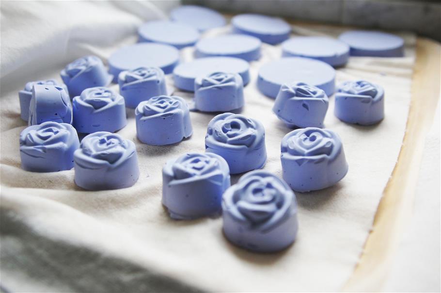 Sinisiä ruusukuvioisia saippuapaloja, jotka on valmistettu luonnonraaka-aineista.